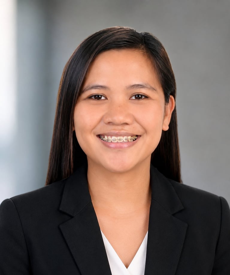Young woman with long dark hair, braces, and a bright smile wearing a black blazer and white shirt against a gray background